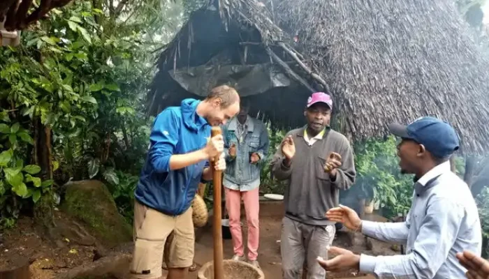 Clients experiencing traditional coffee making in Materuni Village on the Materuni Waterfalls & Coffee Tour cultural day trip from Arusha