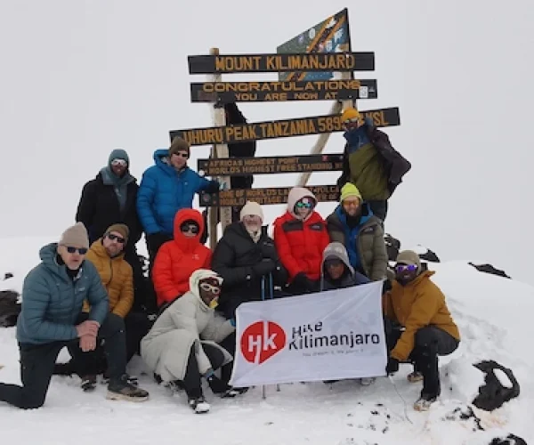 Group of climbers celebrating at Uhuru Peak during 6-Day Marangu Route – Group Join Trek on Mount Kilimanjaro