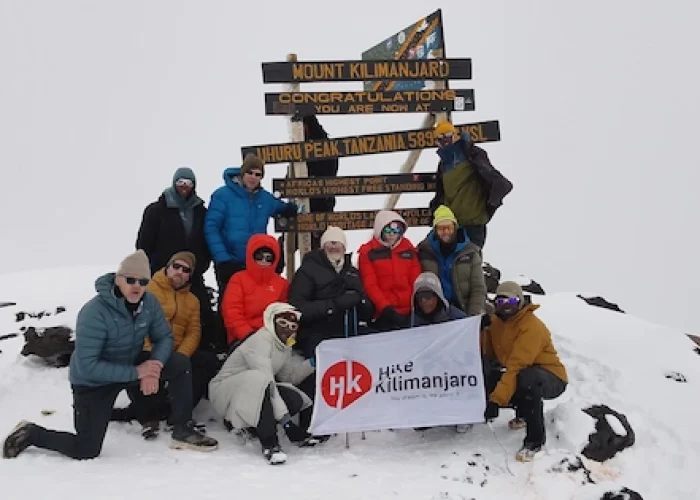 Group of climbers celebrating at Uhuru Peak during 6-Day Marangu Route – Group Join Trek on Mount Kilimanjaro